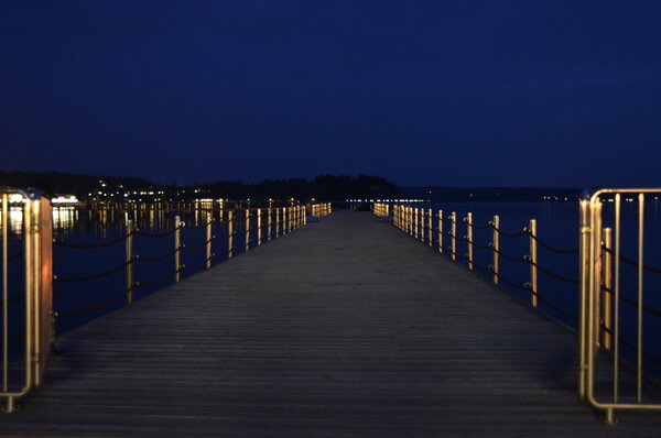 Muelle sobre agua con luz suave de mediodía